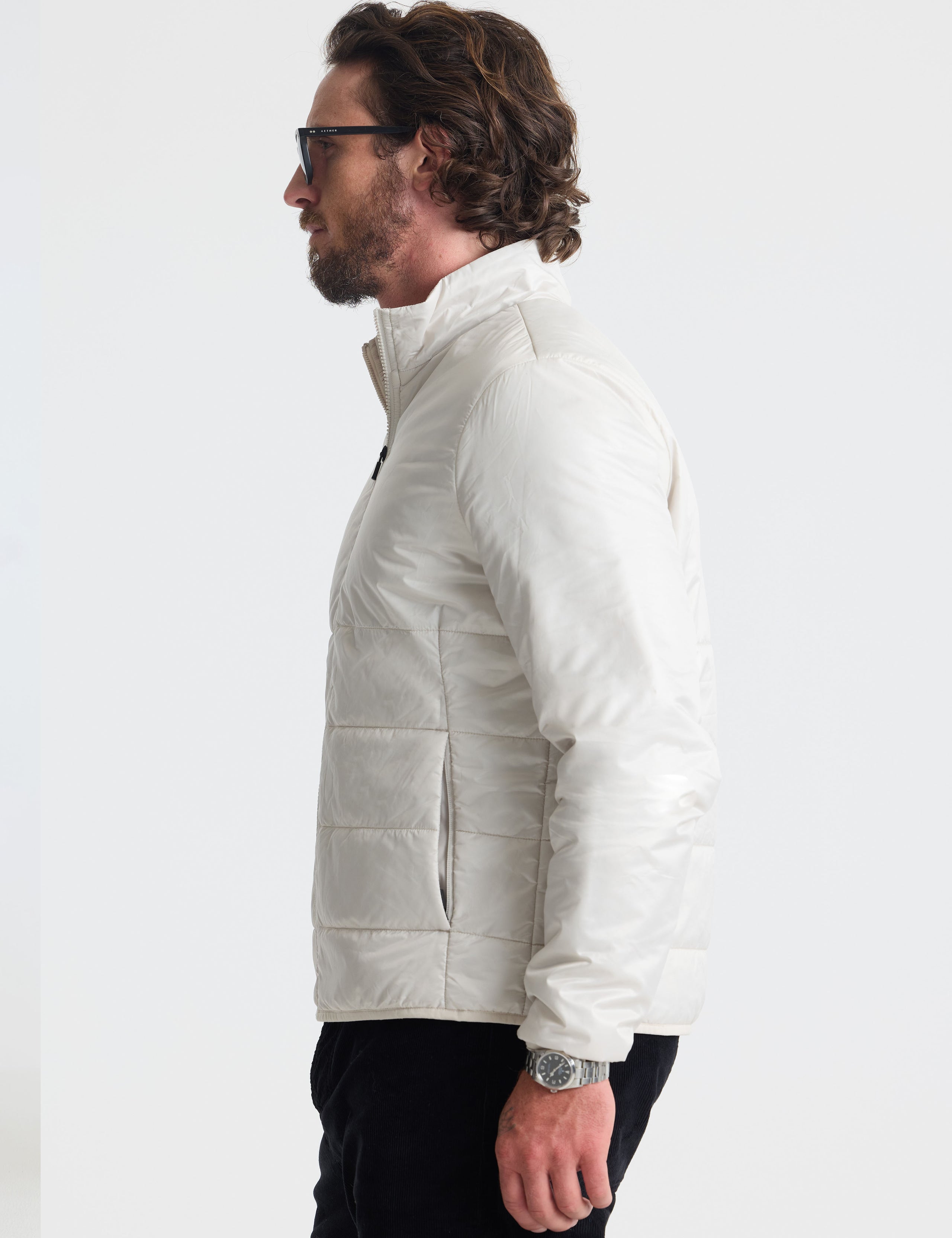 Left profile view of man wearing Eco Insulated Jacket in Bone white from AETHER Apparel.