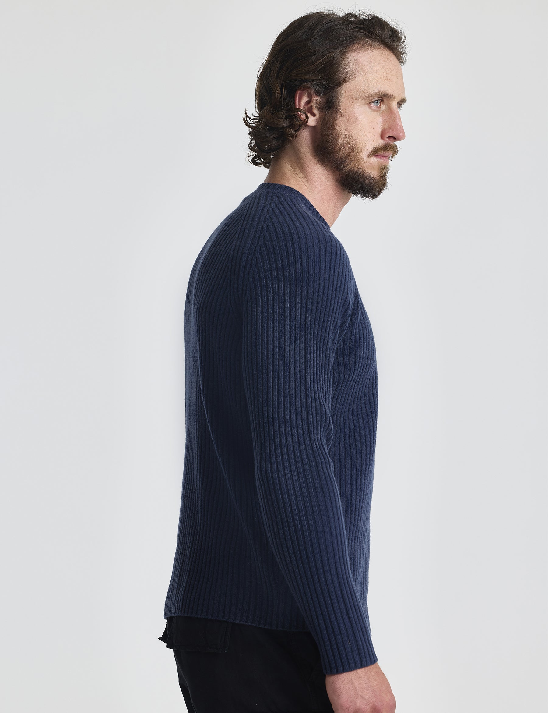 Right profile of man wearing Lyon Sweater in Total Eclipse dark blue from AETHER Apparel.
