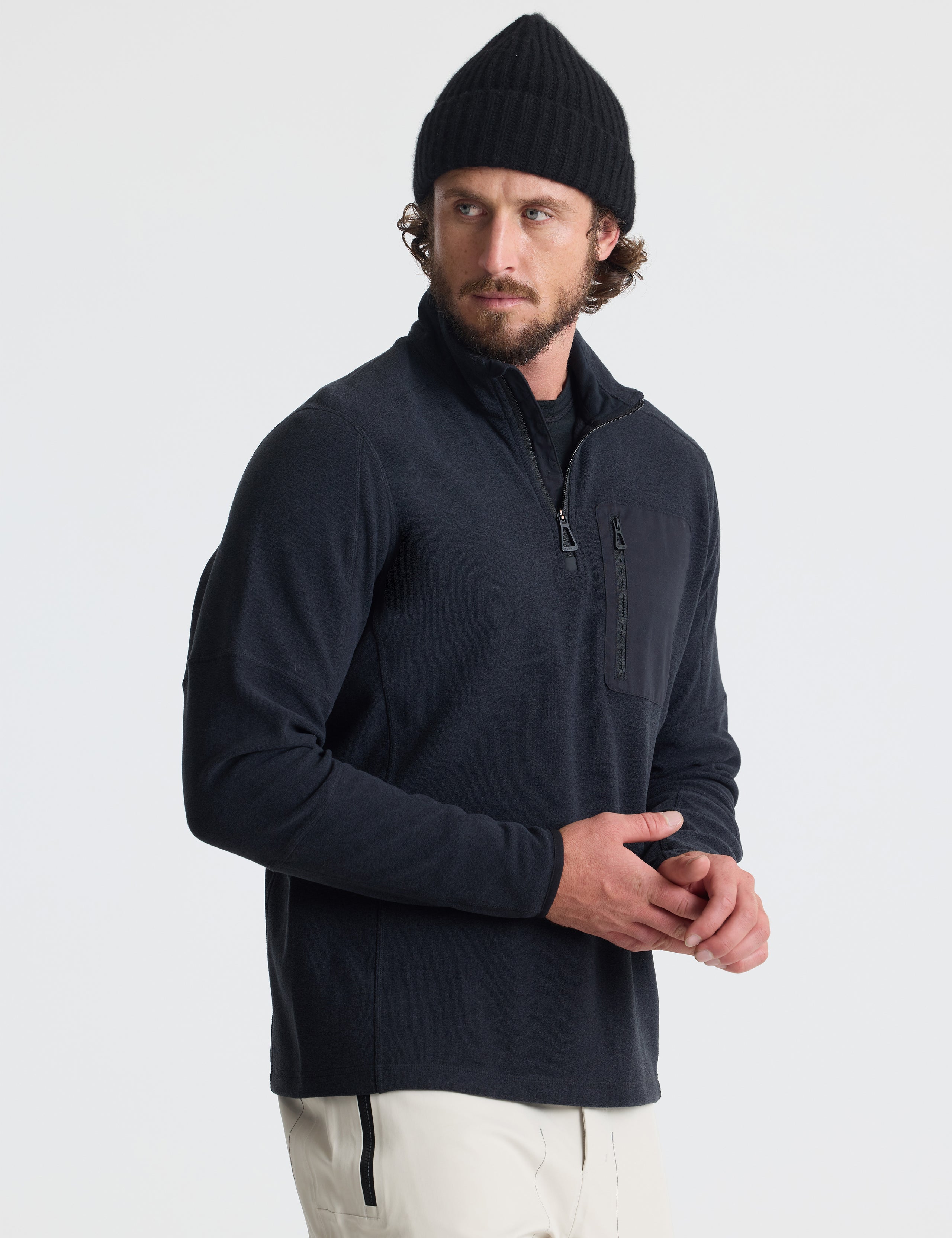 Angled view of man wearing Sutherlin Half-Zip in Onyx Black from AETHER Apparel.